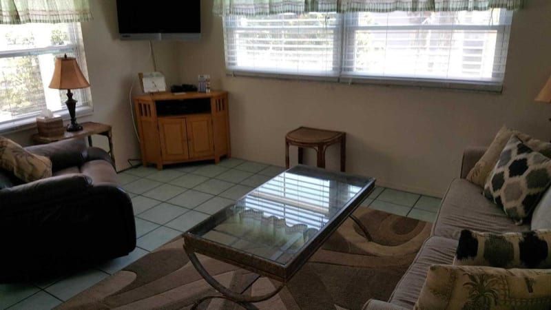 A living room with a couch , chair , coffee table and television.