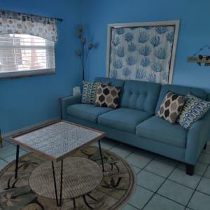 A living room with a blue couch and a coffee table.