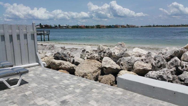 A chair is sitting on a dock next to a body of water.