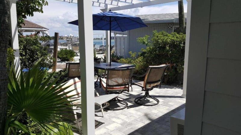 A patio with a table and chairs under an umbrella.