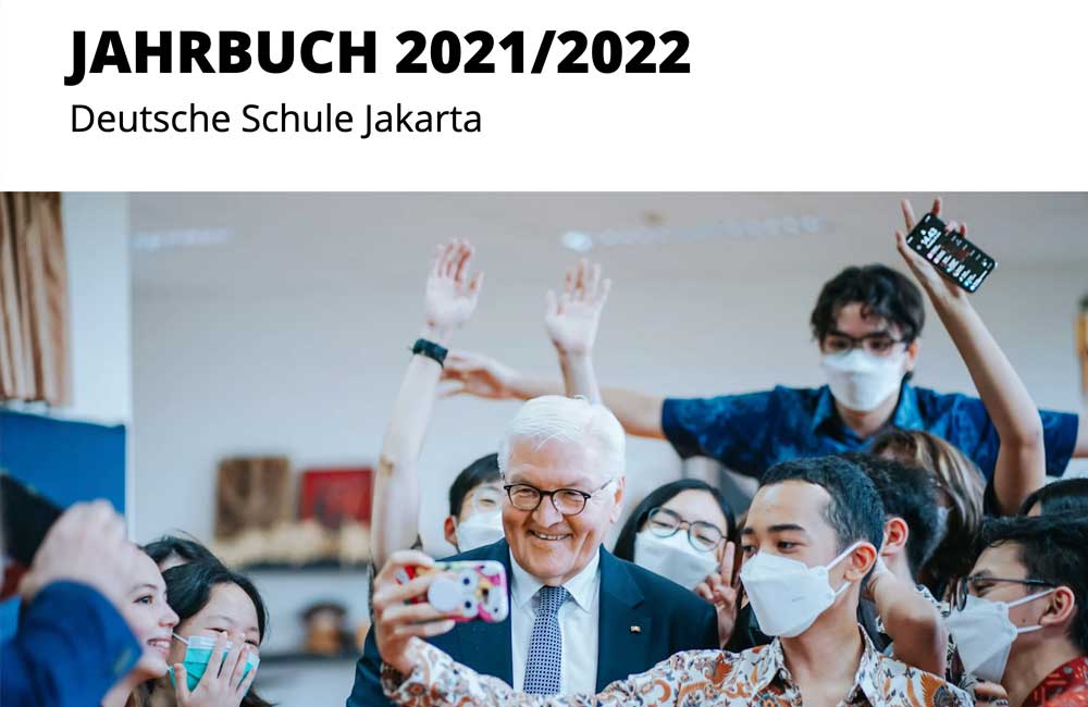 A man in a suit is taking a selfie with a group of people.