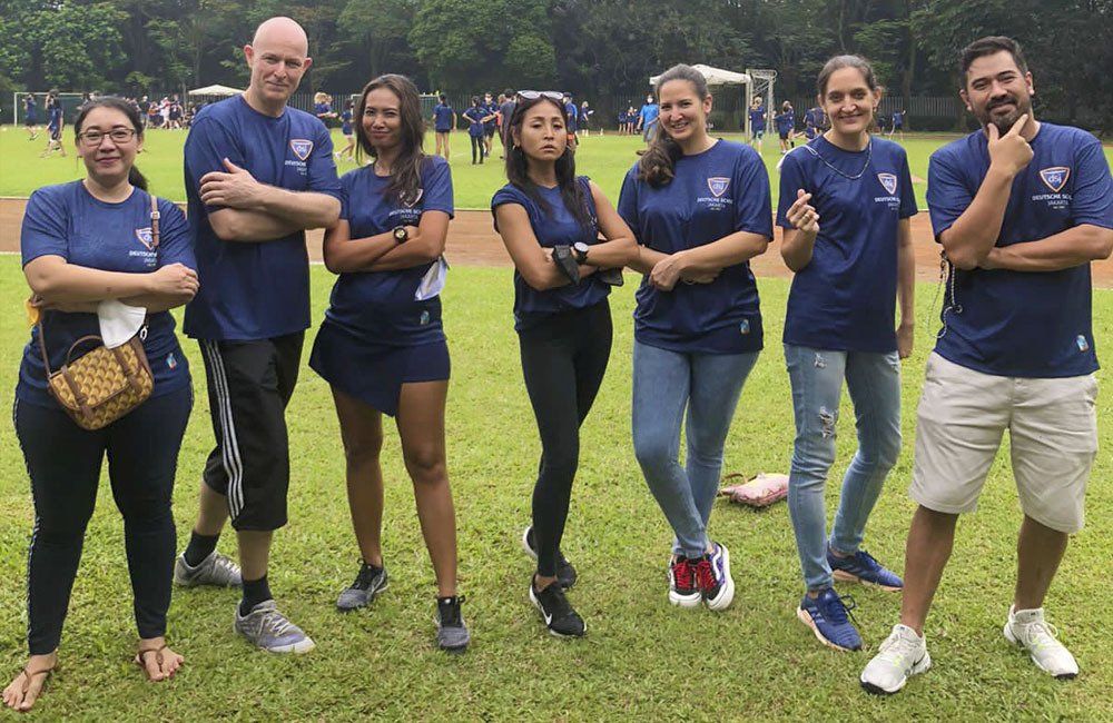A group of people are posing for a picture on a field.