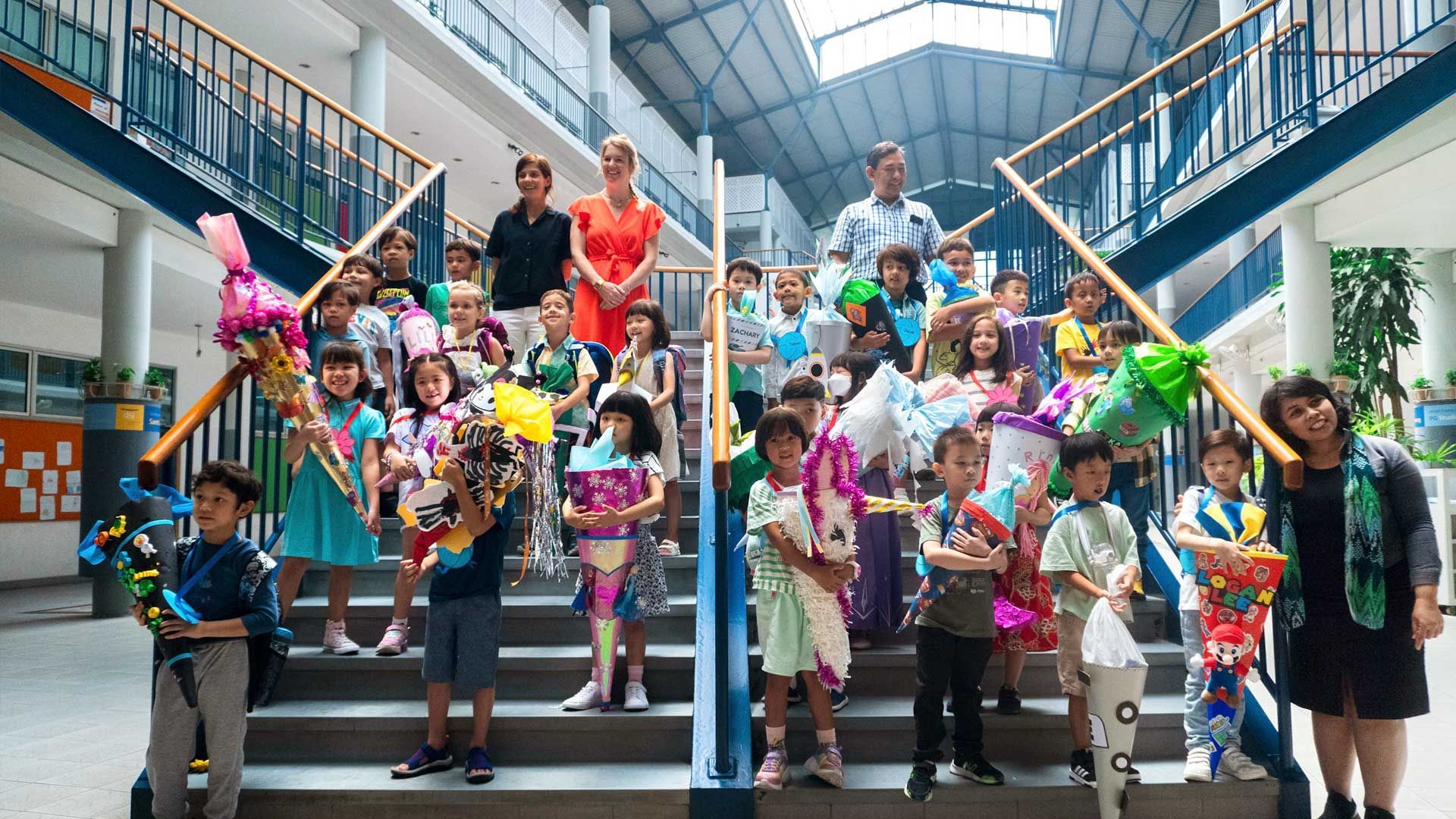 New first graders posing on stairs in the school hall of the german School Jakarta