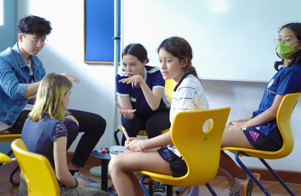 A group of children are sitting in a circle in a classroom.