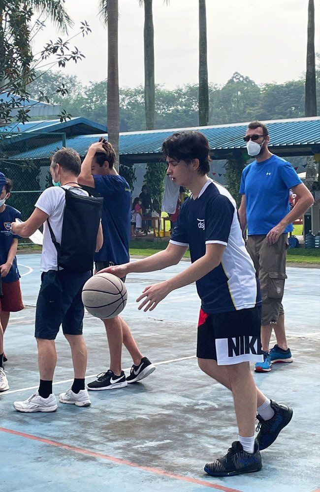 A group of people are playing basketball on a court.