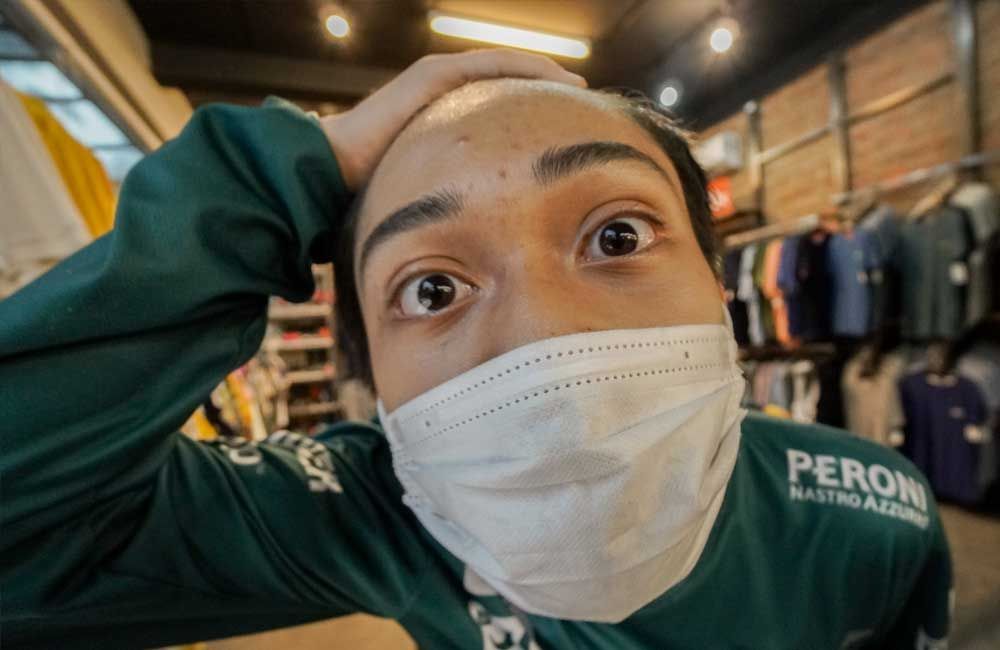 A man wearing a mask and a green shirt is making a funny face.