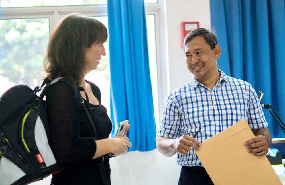 A man and a woman are talking to each other in a room.