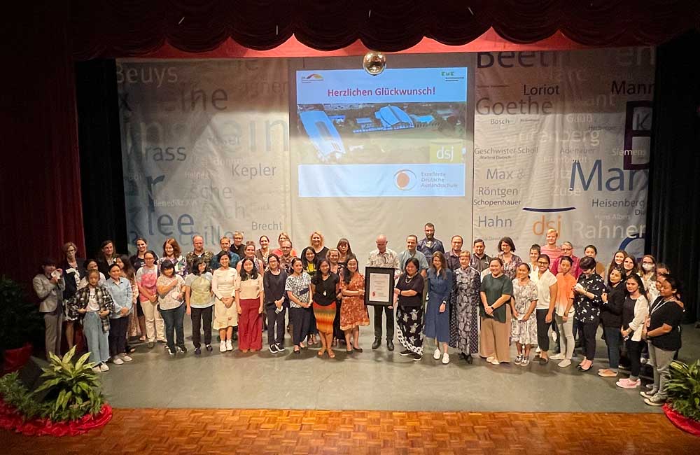 A large group of people are posing for a picture on a stage.