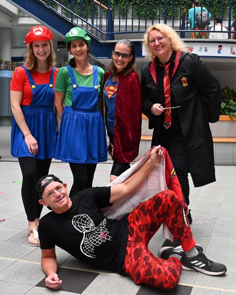 A group of people dressed in costumes are posing for a picture