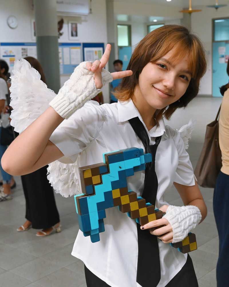 A girl in a white shirt and tie is holding a minecraft diamond pickaxe