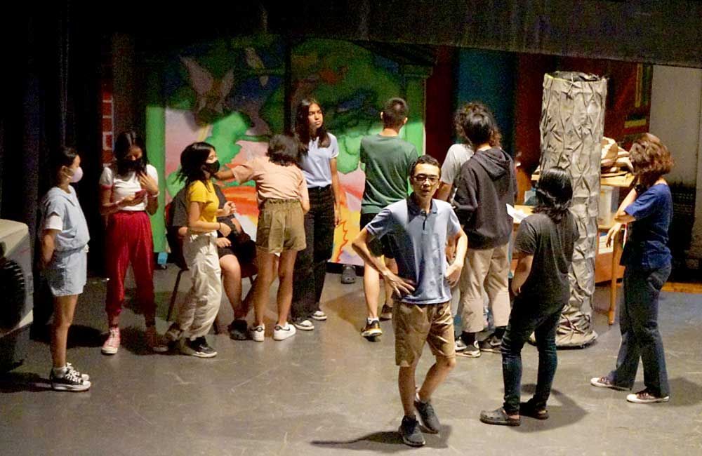 A group of people are standing in a circle on a stage.