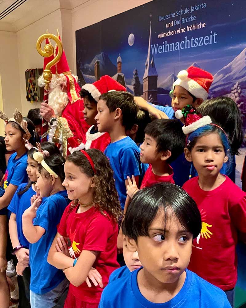 A group of children are standing in front of a sign that says weihnachtszeit.