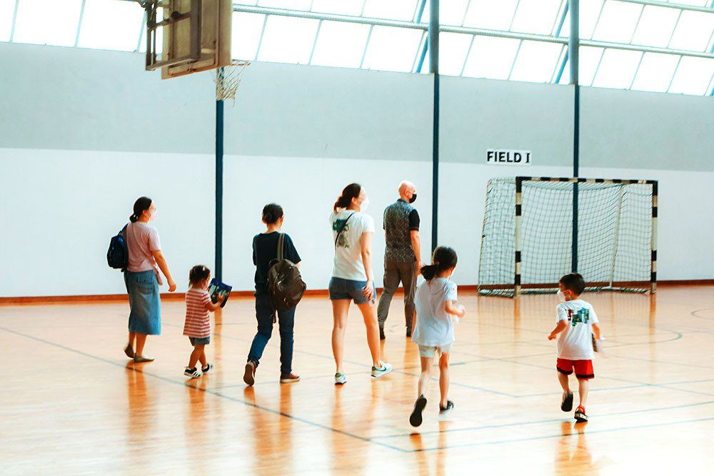 A group of people are standing on a basketball court.