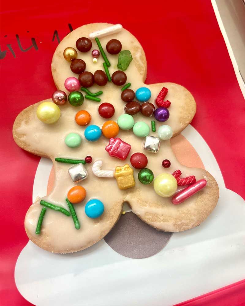 A gingerbread man cookie decorated with candy and sprinkles