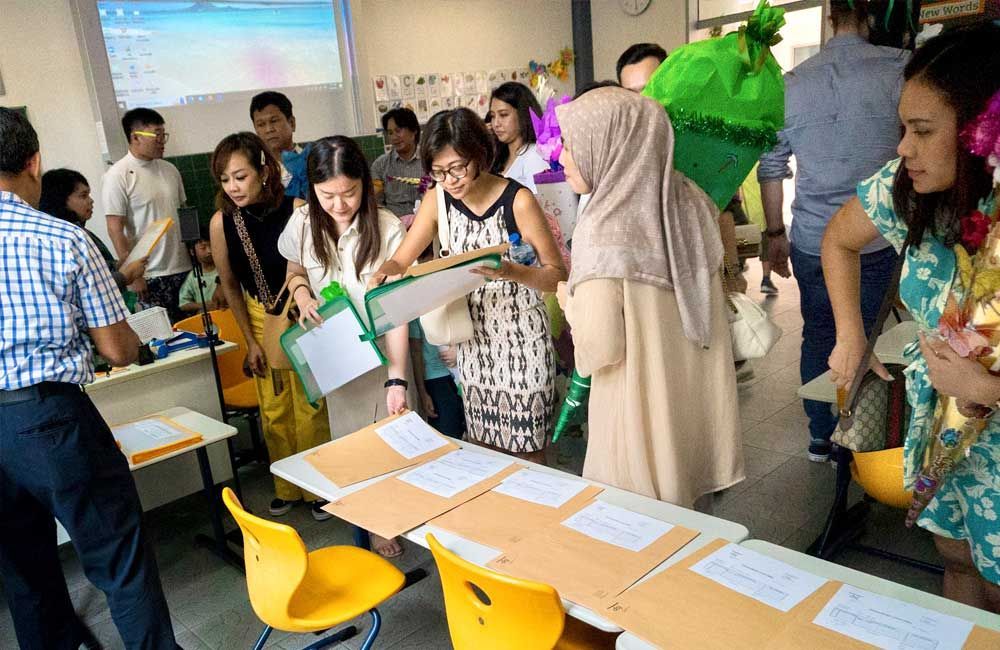 A group of people are standing around a table in a classroom.