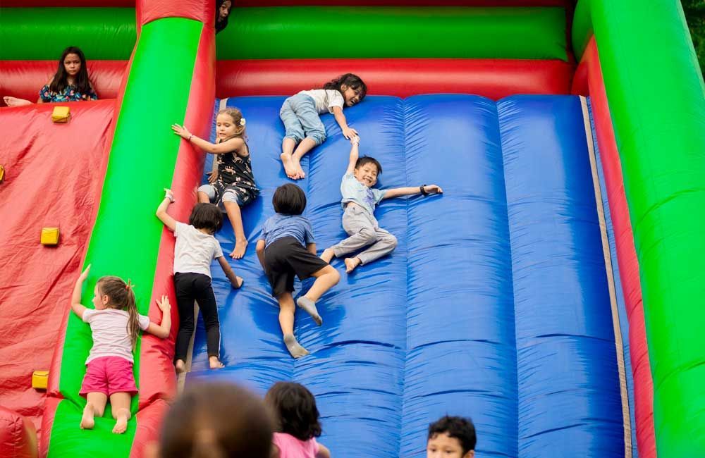A group of children are playing on an inflatable slide.