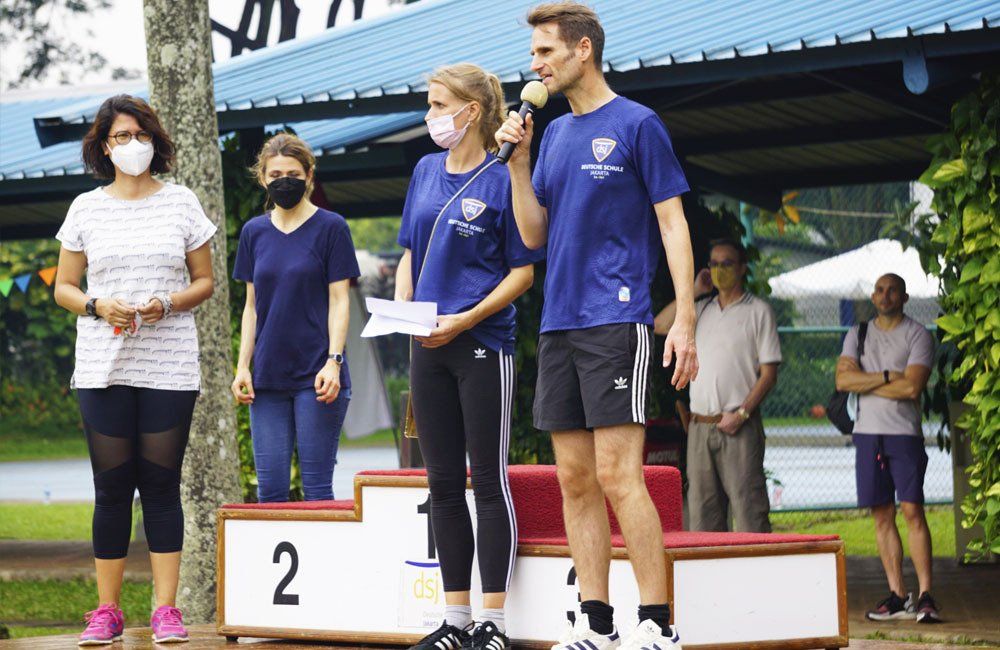 A group of people wearing masks are standing on a podium.