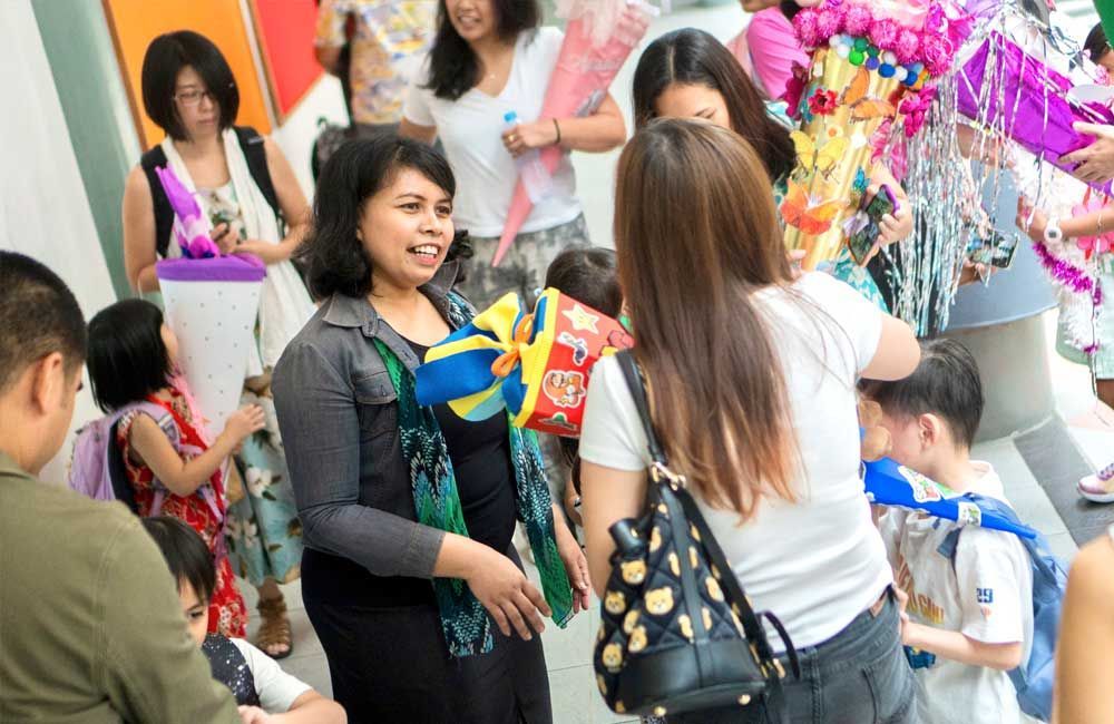 A group of people are standing in a room talking to each other.