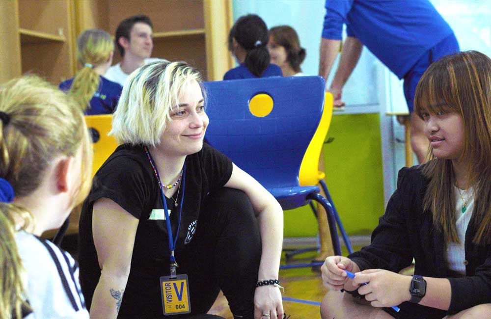 A woman wearing a lanyard with the letter v on it