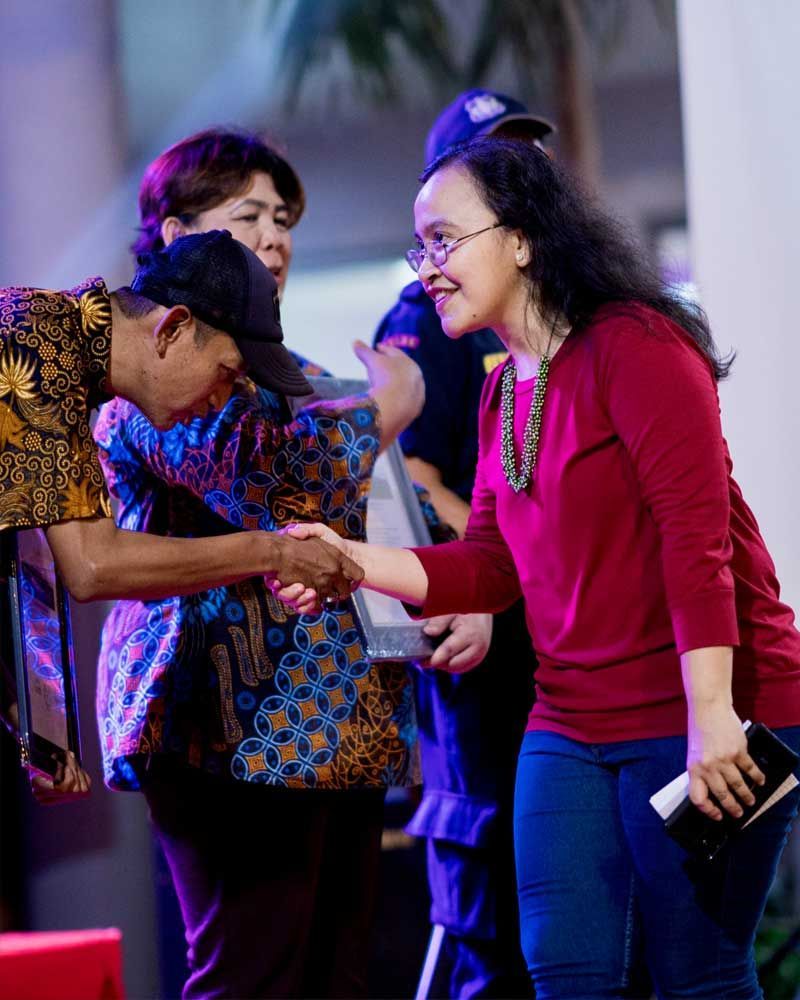 A man is shaking hands with a woman in a red shirt