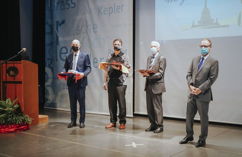 A group of men wearing face masks are standing on a stage.