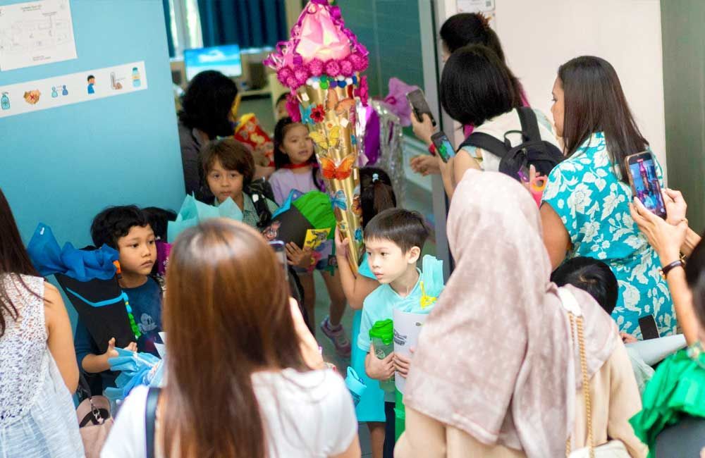 A group of people are standing in a room with balloons.