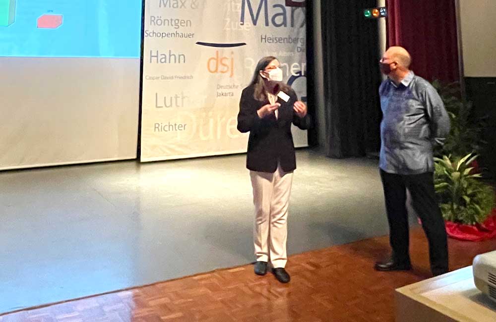 A man and a woman are standing on a stage giving a presentation.