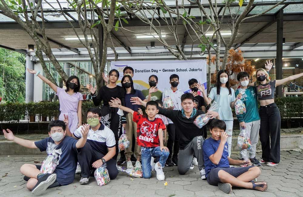 A group of children wearing masks are posing for a picture.