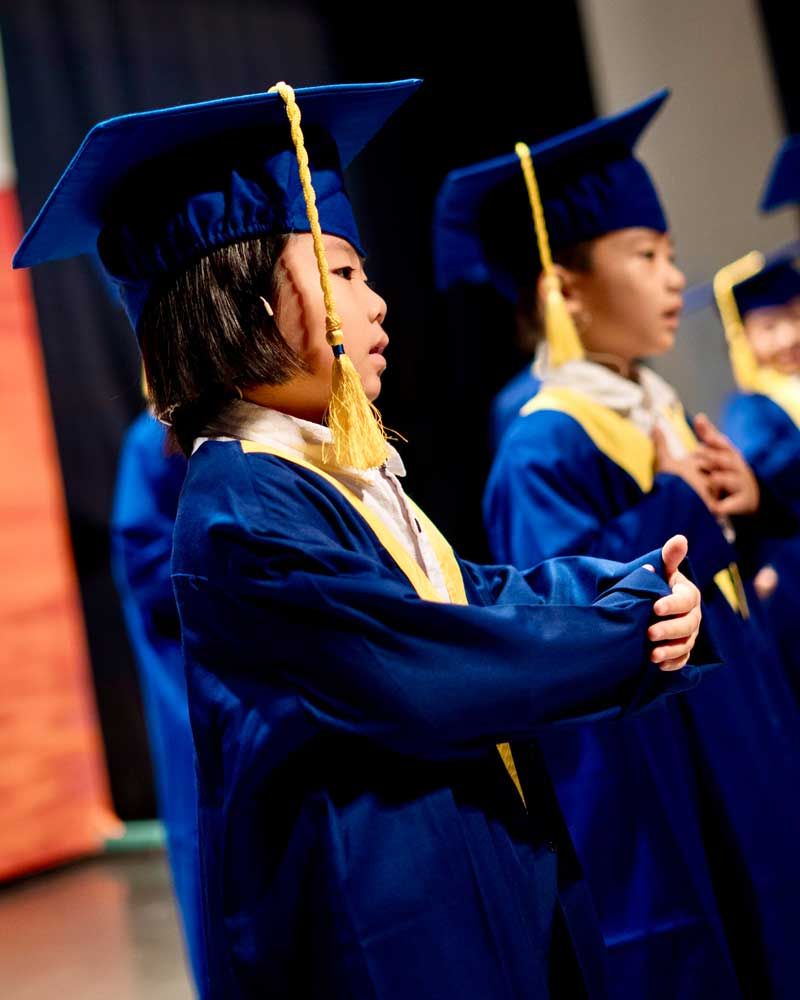 A group of children wearing graduation caps and gowns