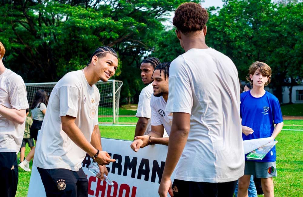 A group of young men are shaking hands on a field.
