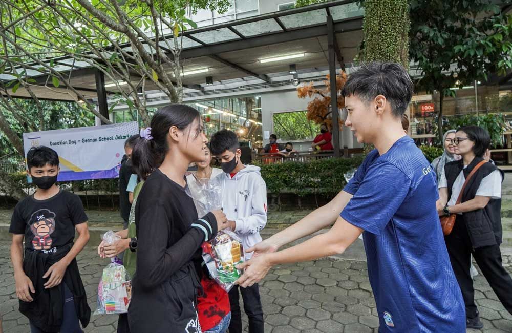 A man is handing a woman a bag of food.