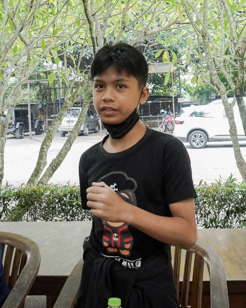 A young boy wearing a black shirt with a chef on it