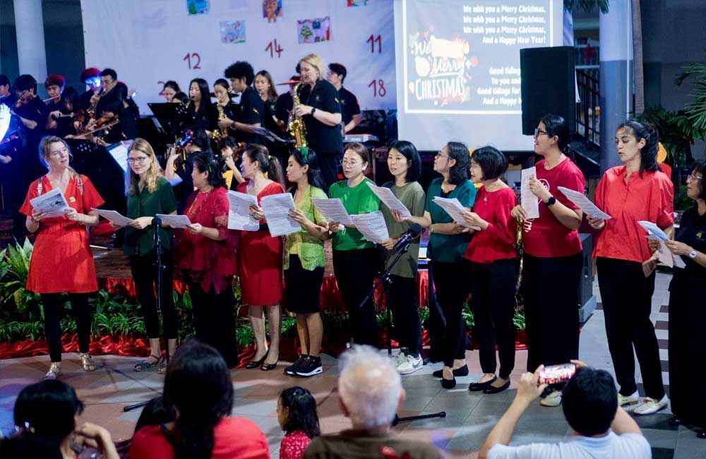 A group of people are singing in front of a crowd.