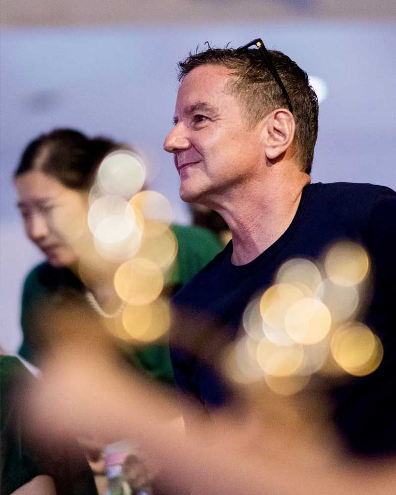 A man in a blue shirt is sitting in front of a woman in a green shirt.