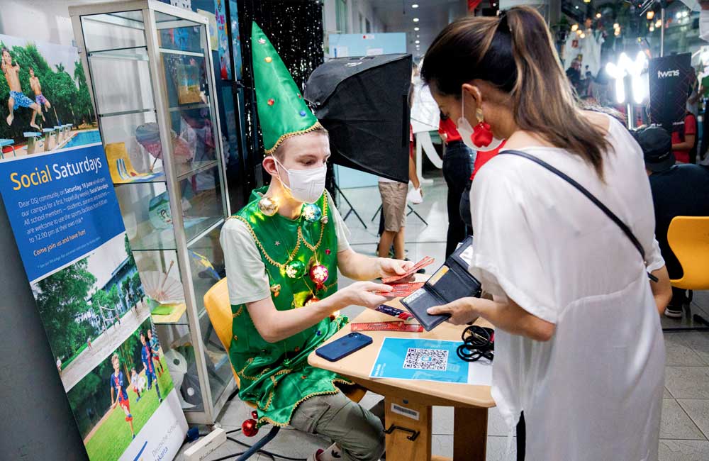 A man in a green elf costume is sitting at a table with a woman.