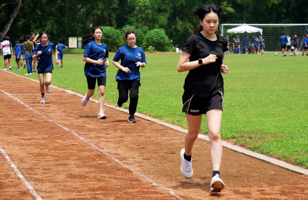 A group of young women are running on a track.