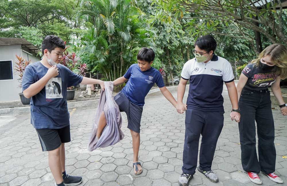 A group of young people are standing next to each other on a sidewalk.