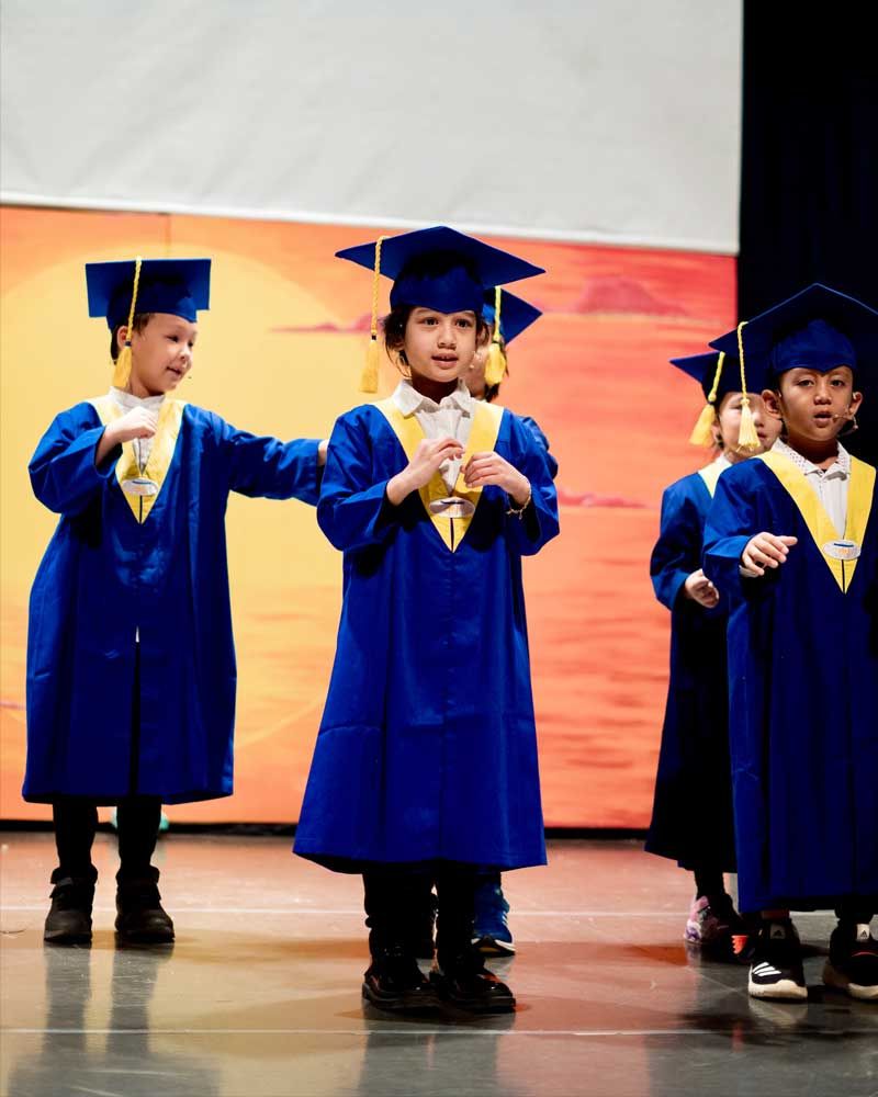 A group of children wearing graduation caps and gowns