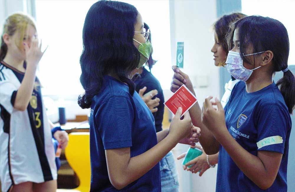 A group of young girls wearing face masks are standing next to each other.