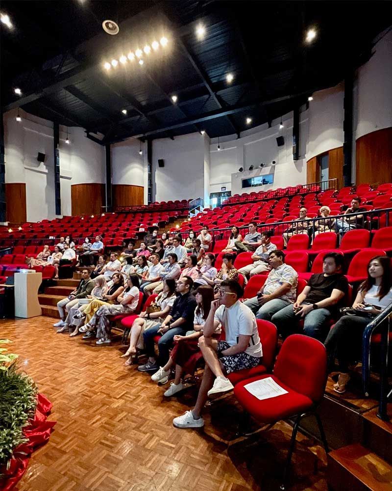 A large group of people are sitting in a large auditorium.