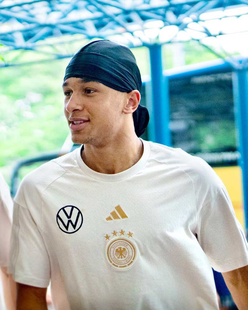 A man wearing a white adidas shirt and a black headband
