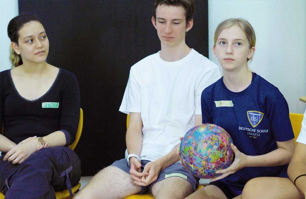 A group of people are sitting on a couch and one of them is wearing a shirt that says provost