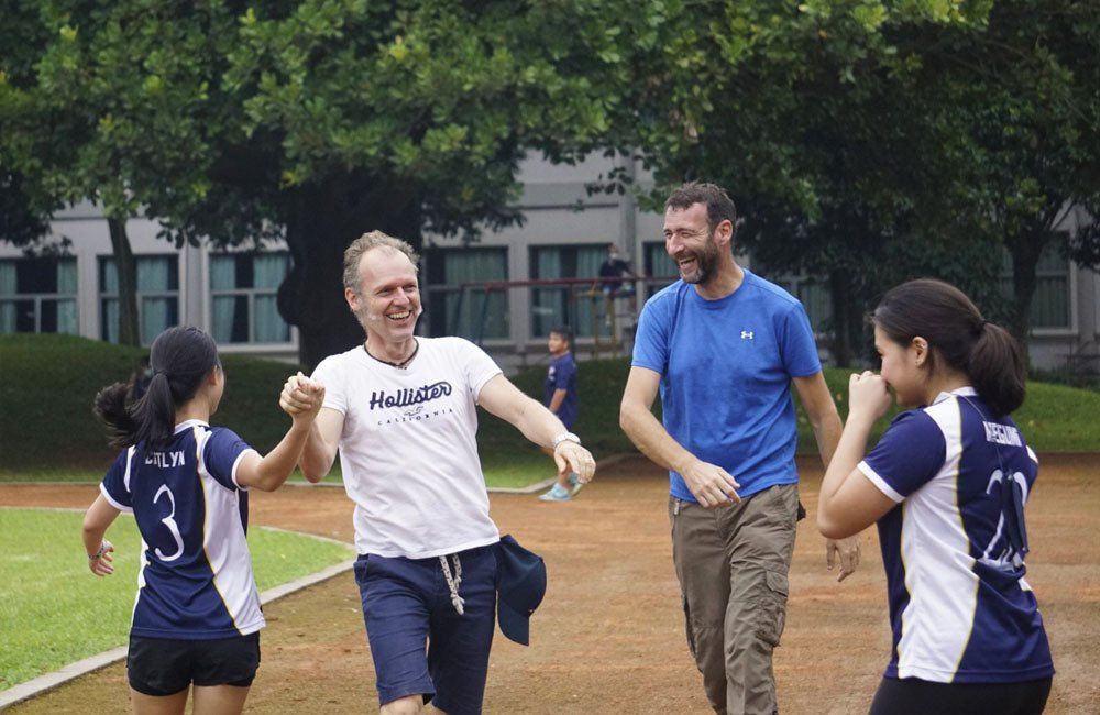 A group of people are standing on a track holding hands.