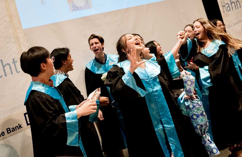 A group of people in graduation gowns are laughing together