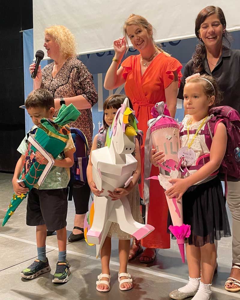 A group of children are standing next to each other on a stage.