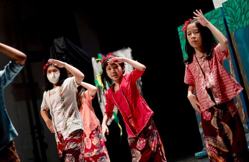 A group of young girls are dancing on a stage.