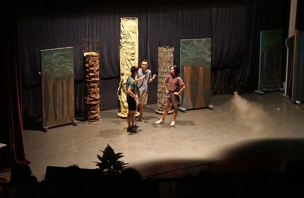 A group of people are standing on a stage talking to each other.