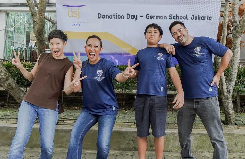 A group of people standing in front of a sign that says donation day