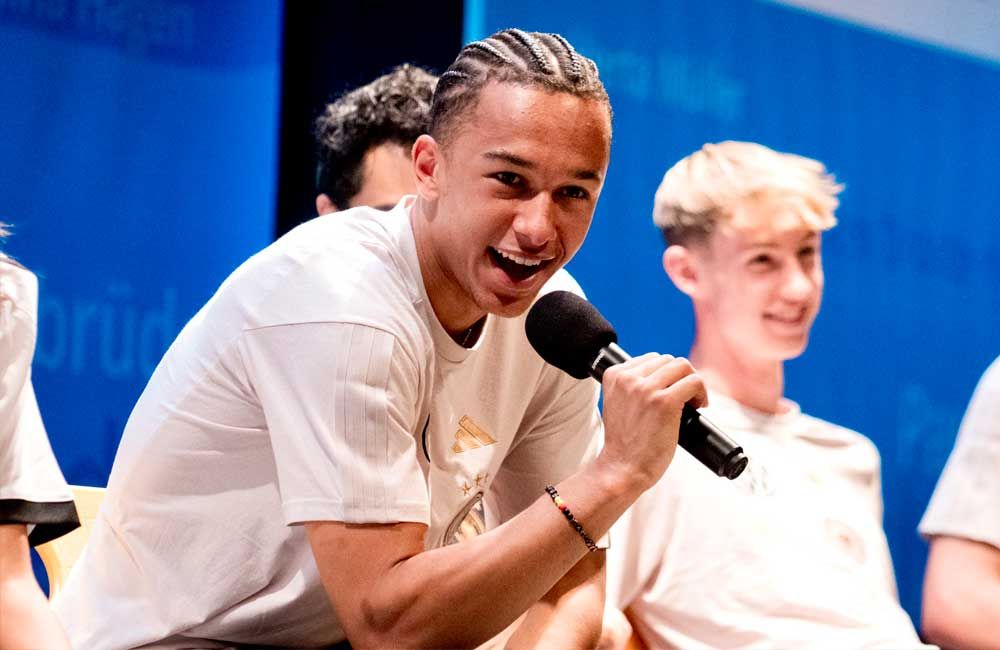 A man is holding a microphone in front of a group of people.