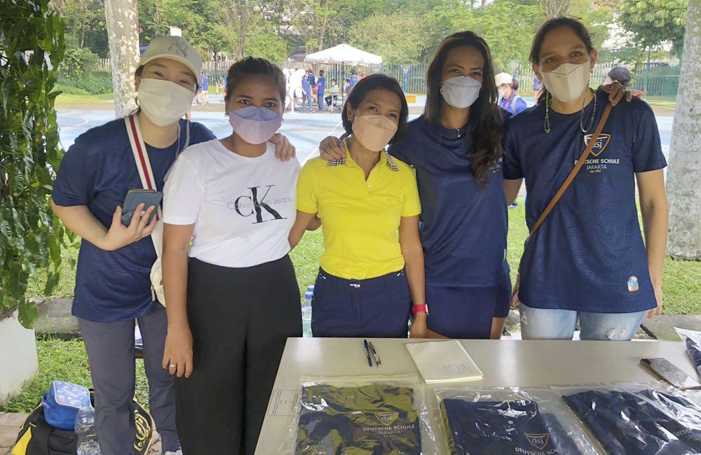 A group of women wearing face masks are posing for a picture.